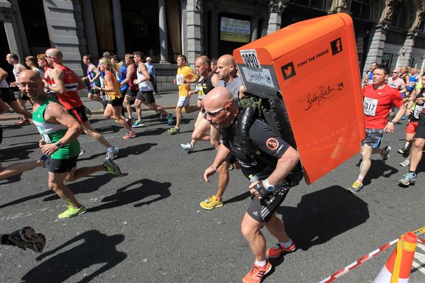 L'UOMO CHE CORRE CON UN FRIGO IN SPALLA PER BENEFICENZA - FOTO - 03/10/2014